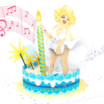 A 3D pop-up greeting card featuring a glamorous blonde woman in a white dress playfully posing as her skirt flutters. She stands atop a decorated birthday cake with blue and white frosting, a striped candle, and yellow starburst decorations. Floating musical notes in pink swirl in the background, indicating a musical element. Confetti and celebratory details enhance the festive scene.