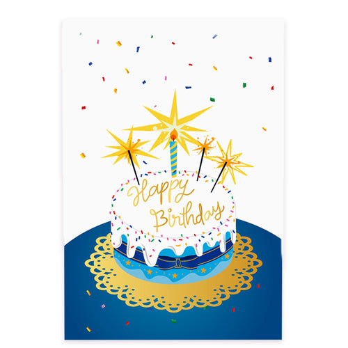 A greeting card cover featuring an illustrated birthday cake with white frosting, colorful sprinkles, and a blue and gold base sitting on an ornate golden doily. The words 'Happy Birthday' are elegantly written in gold script on top of the cake. A striped blue and yellow candle stands in the center, surrounded by bright golden sparklers. Multicolored confetti falls in the background, adding to the festive atmosphere.