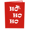 A red greeting card cover with the text HO HO HO in bold, white letters, with the top O wearing a Santa hat. The design is simple and festive, evoking a cheerful holiday spirit.