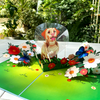 A 3D pop-up greeting card featuring a cheerful Labrador wearing a protective cone, sitting in a vibrant garden. The dog is surrounded by lush green grass, blooming red, white, and yellow flowers, and fluttering blue butterflies. The card is displayed on a white tiled surface with a background of lush greenery, enhancing its bright and playful design