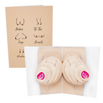 The image shows a greeting card with two views: the front cover features minimalist drawings of various breast shapes labeled with slang terms, while the open card reveals a 3D pop-up illustration of breasts with layered paper elements.