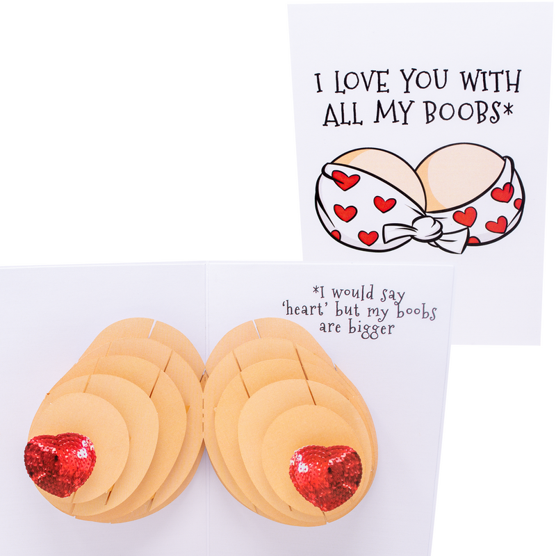 A humorous pop-up greeting card with the front text, I LOVE YOU WITH ALL MY BOOBS and an illustration of a bra with red hearts. Inside, a 3D pop-up of boobs with text, I would say heart but my boobs are bigger.