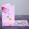 A playful greeting card with a pink cover featuring candy hearts with the text Let's Get Naked. The inside is filled with more candy hearts with flirty messages like Strip Tease and Sensual Massage, creating a fun and cheeky vibe.